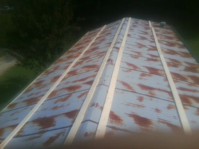 Rusted metal roof panels with new wood purlins before replacement — Storm Damage Roof Repair in Udell by Roofing Brothers