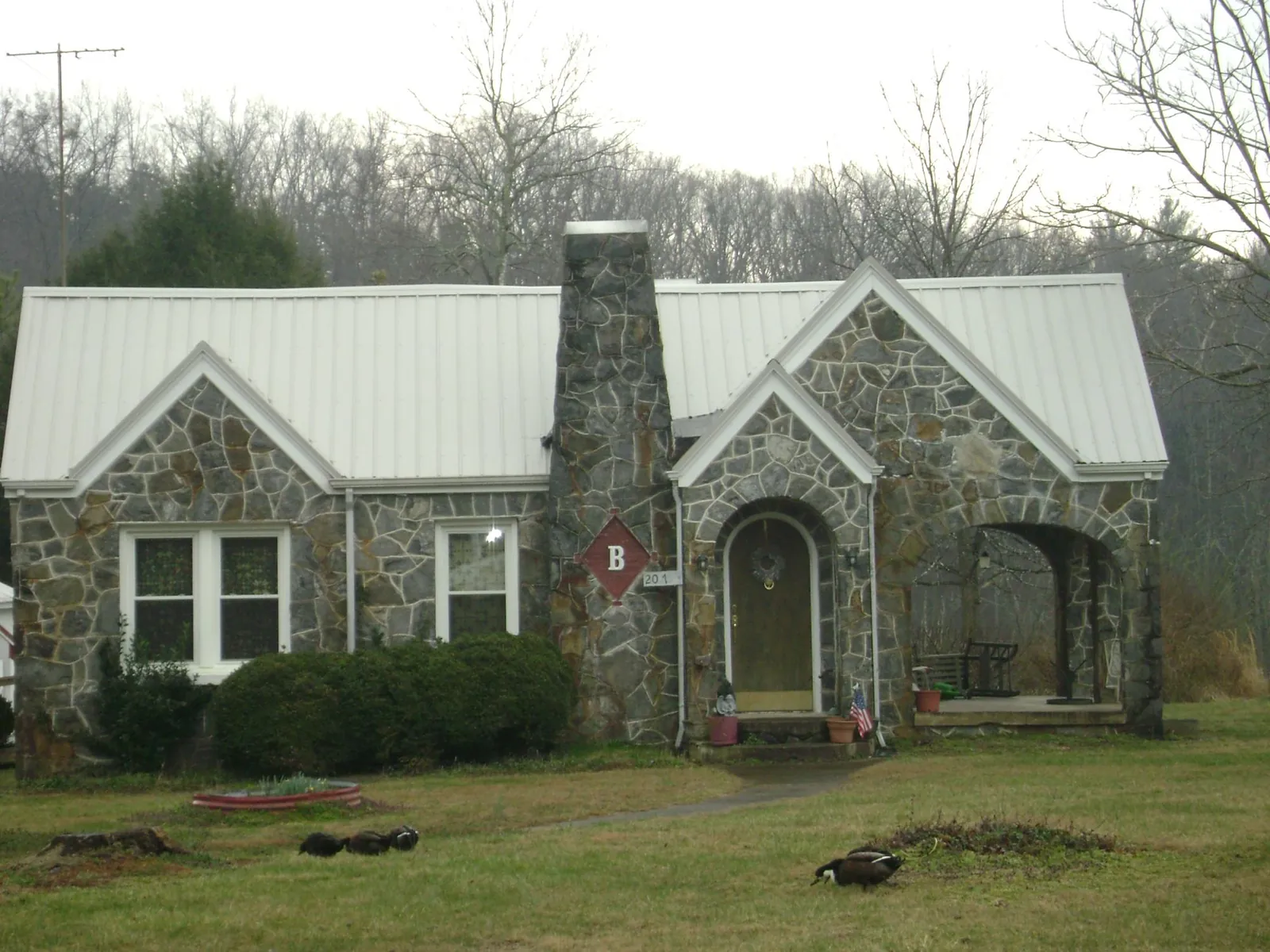 White metal roof on a stone cottage with steep gables in Udell