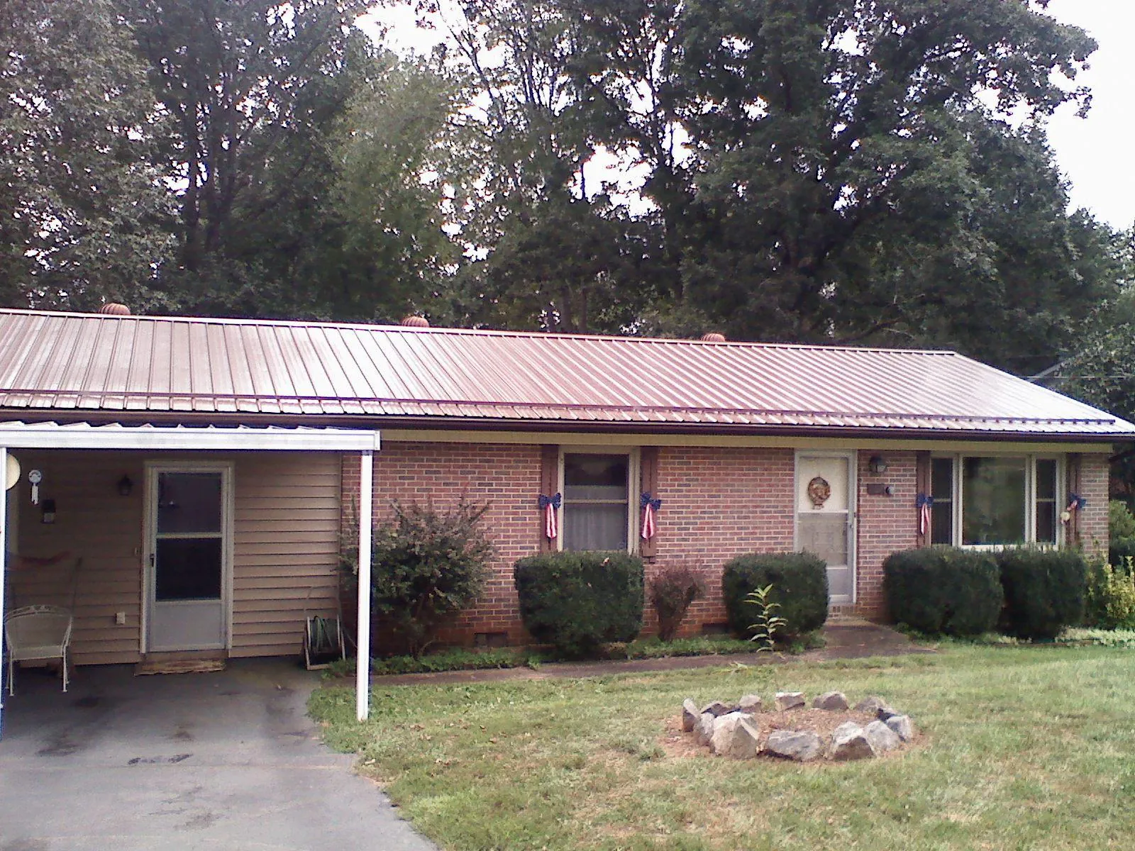 Bronze metal roof and carport on a brick ranch home — Roof Repair work by our crew in Udell
